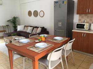 Alexandra Villa في باليون: غرفة معيشة مع طاولة خشبية ومطبخ