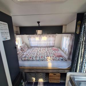 a small bedroom with a bed in a room at Louise´s Camper in Neusiedl an der Zaya
