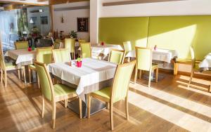 un comedor con mesas y sillas blancas en un restaurante en Agritur Anselmi, en Terzolas