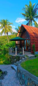 a resort with a red roof and palm trees at Villa Pintu Bintang in Pawenang