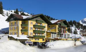 オーバータウエルンにあるHotel Appartement Winterの雪の大きな黄色の建物