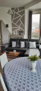 a living room with a couch and a large table at Soucis au vent in De Panne