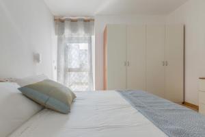 een wit bed met een kussen erop bij Salentoandmore - Casa Stella in Torre Pali 