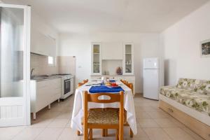 een witte keuken met een tafel en een bank bij Salentoandmore - Casa Stella in Torre Pali 