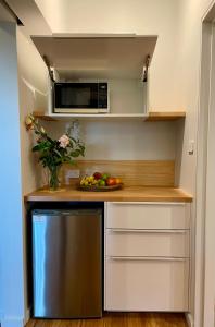 a kitchen with a microwave and a plate of fruit at Tranquil Garden Studio in Wollongong