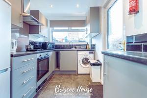 a kitchen with a washer and dryer in it at Briscoe Serviced Accommodation in Manchester