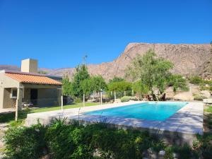 una piscina frente a una casa con montaña en CASAS Viñedos de Cafayate Alquiler Temporario en Cafayate