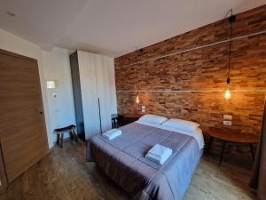 a bedroom with a bed and a brick wall at Arya Cagliari in Cagliari