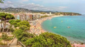 a beach with a bunch of people in the water at Hotel Bella Dolores in Lloret de Mar