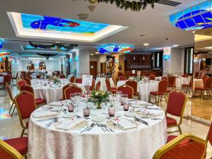a dining room with tables and chairs with white table cloth at Perla Marina in Nerja