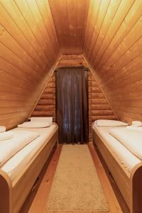 Alpska kuća Lucy في Jasenak: غرفة بثلاث اسرة في كابينة خشبية