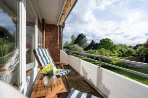 a porch with a chair and a balcony with a view at FeWo Baltic Pelzerhaken in Pelzerhaken