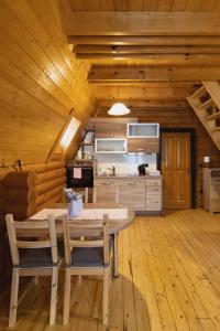 Alpska kuća Lucy في Jasenak: مطبخ وغرفة طعام مع طاولة وكراسي