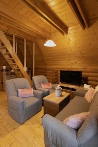 a living room with two couches and a flat screen tv at Alpska kuća Lucy in Jasenak