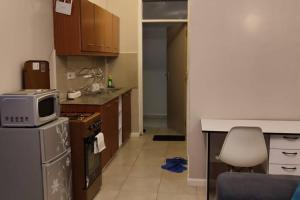 een kleine keuken met een magnetron en een koelkast bij One bedroom fully furnished apartment in Kiambu +6 foto's