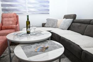 a living room with a couch and two tables with wine glasses at Z&R SUNLIGHT in Trebinje