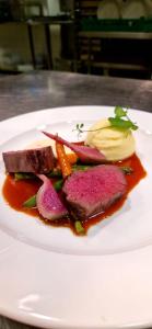 a white plate with meat and vegetables on a table at Sognefjord Hotel in Hermansverk