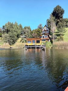 una casa sentada a un lado de un lago en Cabaña de descanso arcoiris del lago 3, en Pasto