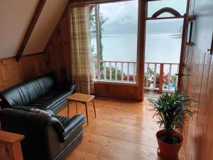 sala de estar con sofá y ventana grande en Cabaña de descanso arcoiris del lago 3, en Pasto