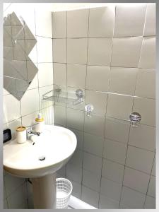 a white bathroom with a sink and a shower at Villa Capozza Maria Greca in Le Castella