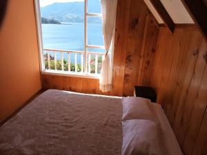 a bedroom with a bed and a large window at Cabaña de descanso arcoiris del lago 3 in Pasto