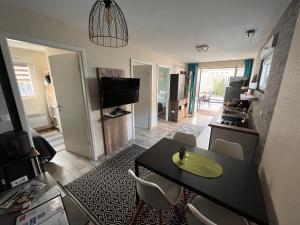 a living room with a table and chairs and a kitchen at Lodge Starlette Spa privatif à Meisenthal in Meisenthal