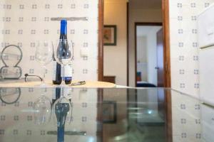 - deux verres à vin et une bouteille sur une table en verre dans l'établissement Terraço da Bineca, à Cortegaça