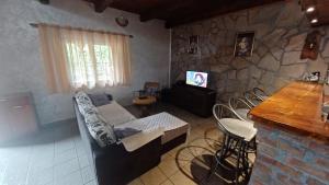 a living room with a couch and a stone wall at Holiday Home Nikolić in Njeguši