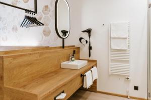 uma casa de banho com um lavatório e um espelho em BEE GREEN Linz Self-Check-in-Hotel em Linz