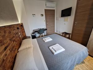 um quarto com uma cama com duas toalhas em ARYA Cagliari em Cagliari