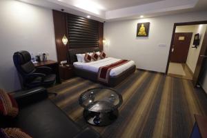 Habitación de hotel con cama y silla en HOTEL AVN GRAND, en Ranchi