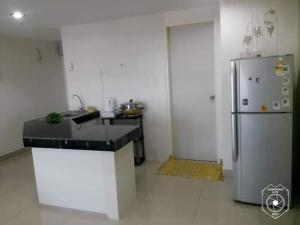 a kitchen with a sink and a refrigerator at KB Studio @D'Perdana Apartment in Kota Bharu