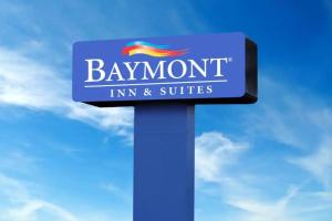 un cartello blu per una locanda e suite di bbaymont di Baymont by Wyndham Carlsbad NM a Carlsbad