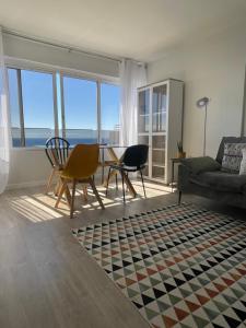 ein Wohnzimmer mit einem Sofa und einem Tisch mit Stühlen in der Unterkunft top floor avenida arriaga 802 in Funchal