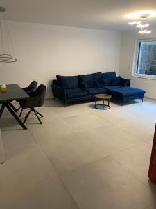 a living room with a blue couch and a table at Charmante Ferienwohnung-Neubau- in Taunusstein +1 photo