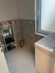 a bathroom with a sink and a shelf with towels at Charmante Ferienwohnung-Neubau- in Taunusstein