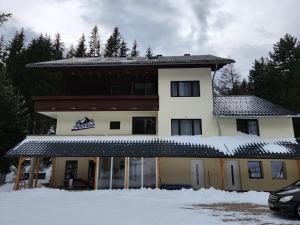 um grande edifício com neve em frente em AlpenKlub Hotel em Vordernberg