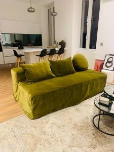 a green couch sitting in a living room at Appartement Design sur Vauban - Clim et Wifi in Marseille