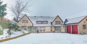 une maison avec de la neige au sol dans la cour dans l'établissement Blythewood Guest House, à Coleshill