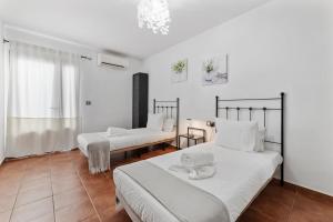 una camera con due letti con lenzuola bianche di Home2Book Luxury Villa Playa Honda, Private Pool a Playa Honda