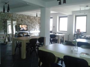 un restaurante con mesas y sillas y una pared de piedra en Hotel Hinovi Hvoyna en Hvoyna