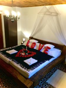 a bedroom with a bed with red pillows on it at Mátrai pincés udvar in Mátramindszent