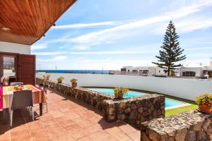 プラヤ・オンダにあるHome2Book Luxury Villa Playa Honda, Private Poolの石壁のパティオ、スイミングプールが備わります。