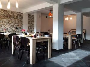 a restaurant with tables and chairs and a stone wall at Hotel Hinovi Hvoyna in Hvoyna