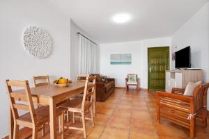 a dining room and living room with a table and chairs at Casa Las Vistas in Gran Tarajal