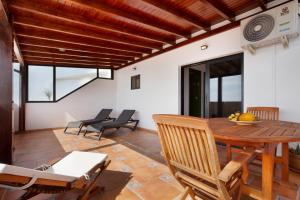 a dining room with a wooden table and chairs at Casa Las Vistas in Gran Tarajal