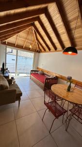 sala de estar con mesa y cama en Hermoso departamento en el centro de SMA con balcón. 4/2 en San Martín de los Andes