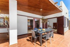 una sala da pranzo con tavolo e sedie di Home2Book Luxury Villa Playa Honda, Private Pool a Playa Honda