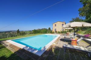 a swimming pool in front of a house at Agriturismo La Casellina in Monticchiello