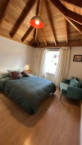 Un dormitorio con una cama verde y una ventana en Hermoso departamento en el centro de SMA con balcón. 4/2 en San Martín de los Andes